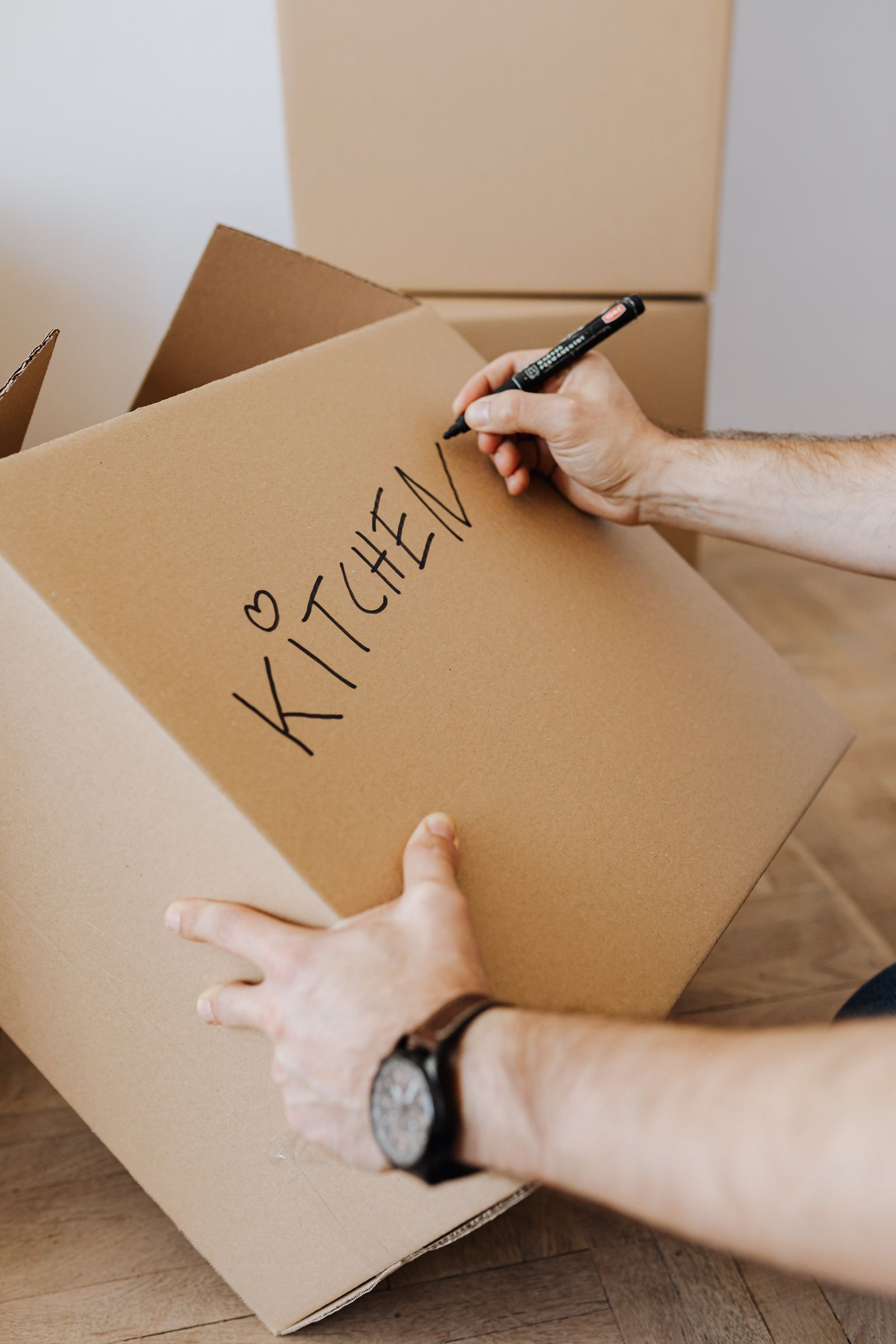 A box being labelled kitchen so it lands in the right room