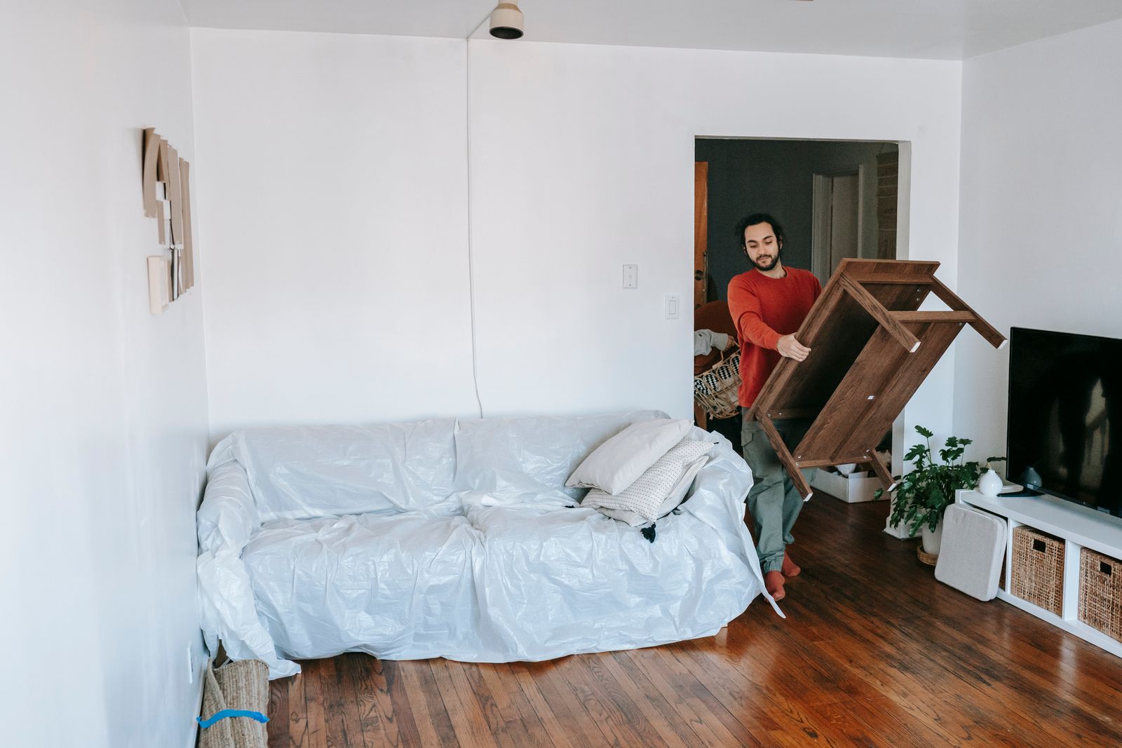 A Nyati Movers crew member carrying a wooden table carefully through a room