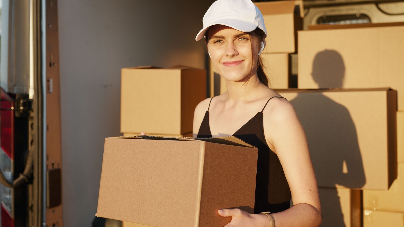 A mover holding a box at the tail of a loaded truck