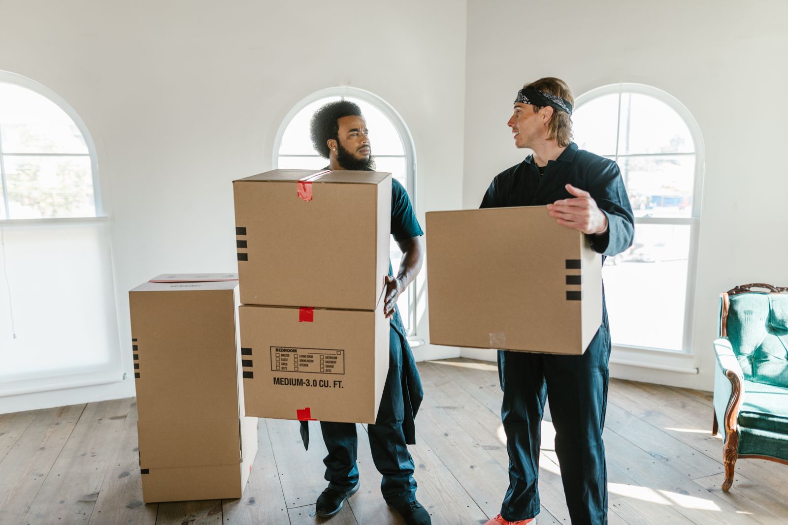 A Nyati Movers crew carrying boxes through an empty living room