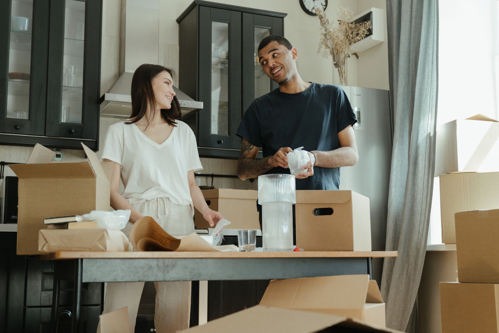 Glassware being wrapped and packed in a kitchen ahead of a move