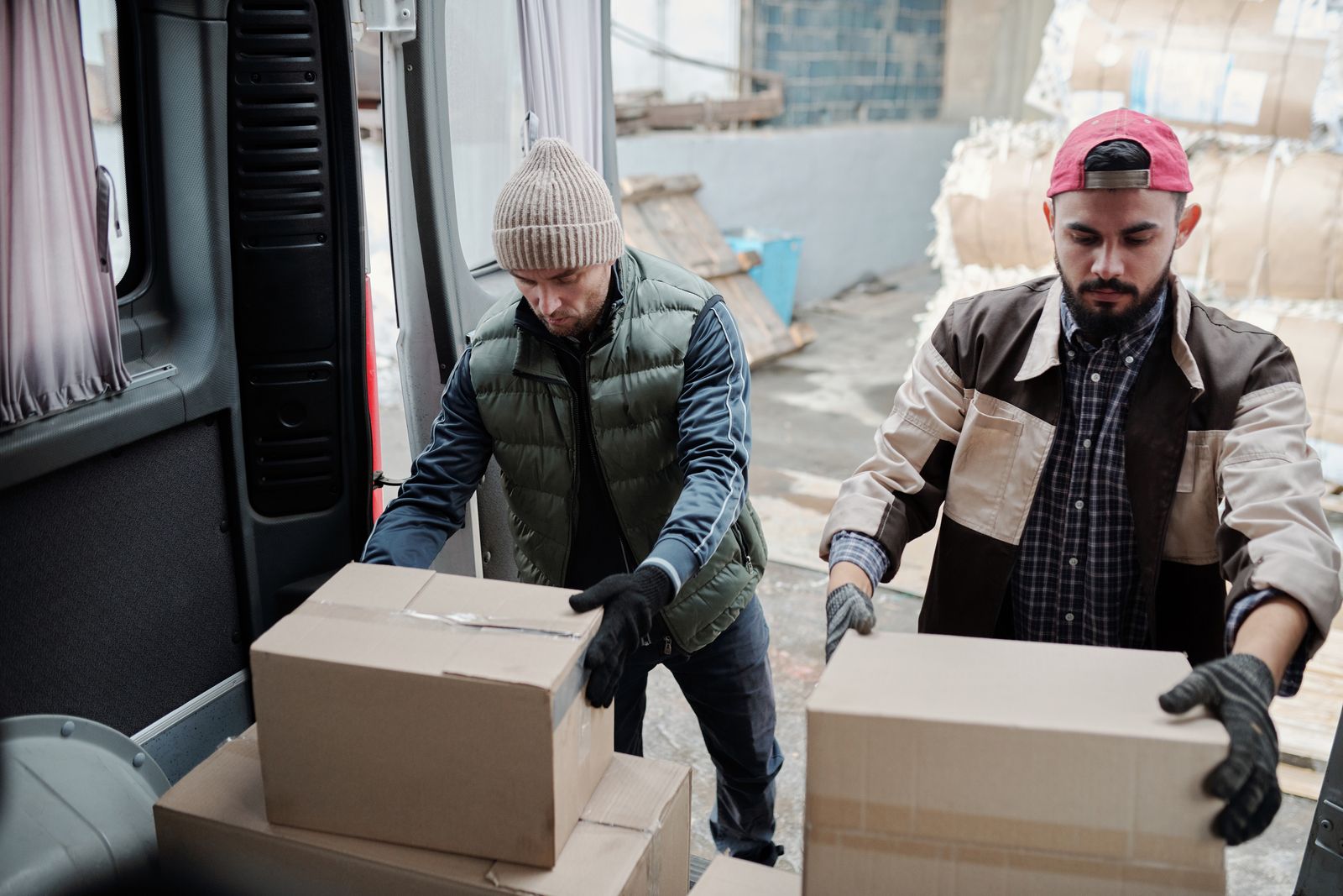Two movers lifting boxes into a van during a move